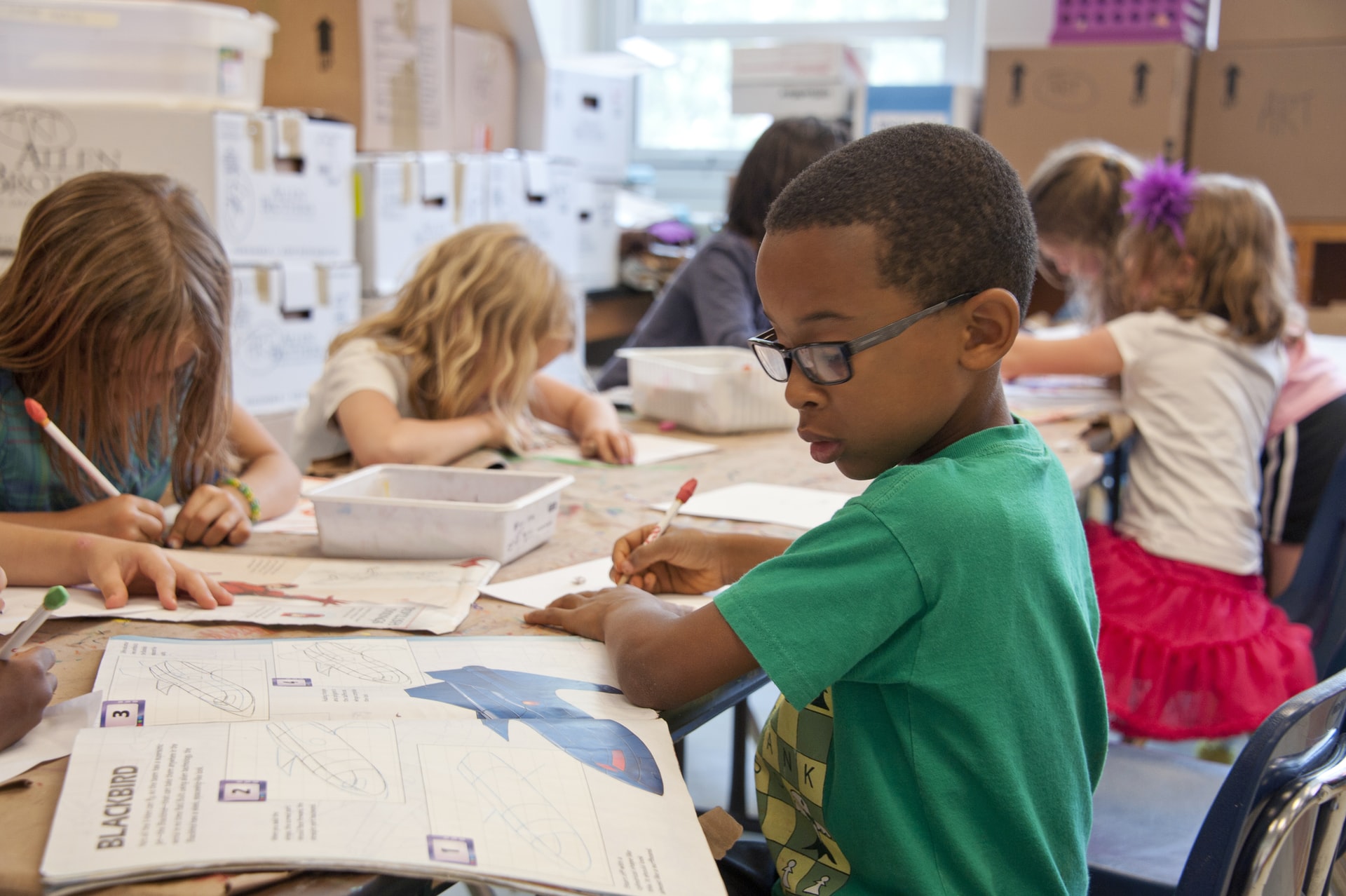 a kid drawing in a classroom